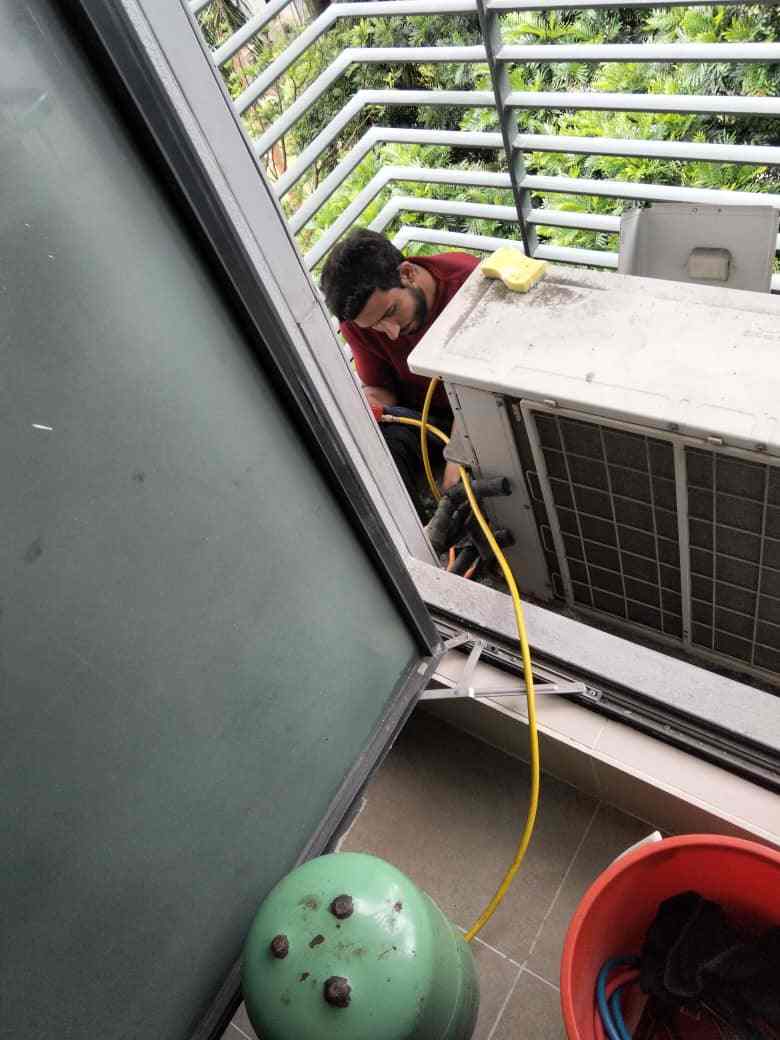 Technician fixing an aircond compressor