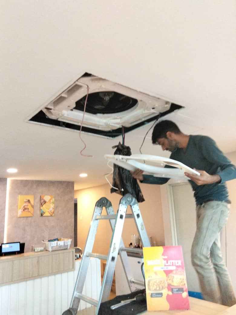 Technician servicing a ducted aircond